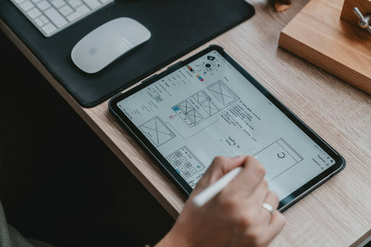 Tablet showing website wireframe sketches on a desk